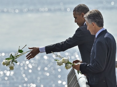 US President Barack Obama (L) and Argentinian President Mauricio Macri throw a bouquet of white flowers into the River Plate as they pay homage to Dirty War's victims. Getty Images