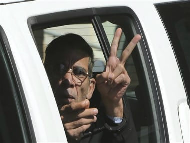 EgyptAir plane hijacking suspect Seif Eddin Mustafa flashes the victory sign as he leaves a court in a police car after a remand hearing as authorities investigate him on charges including hijacking, illegal possession of explosives and abduction in the Cypriot coastal town of Larnaca Wednesday, March 30, 2016. AP