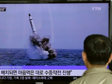 A South Korean man watches a TV news program showing an image published in North Korea's Rodong Sinmun newspaper of North Korea's ballistic missile believed to have been launched from underwater. AP