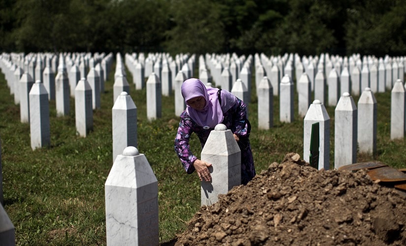 A file image of a woman touching the tombstone of a relative at the Potocari, memorial complex near Srebrenica. AP