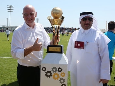 FIFA President Gianni Infantino (L) poses for a picture with the workers football cup trophy during a match ahead of a press conference in the Qatari capital Doha. AFP