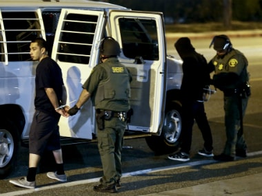 Law enforcement officers take two protesters into custody after a rally for Donald Trump on Thursday.