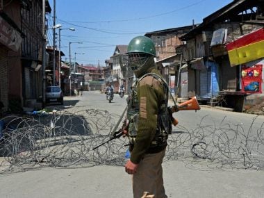 A jawan stands at guard in curfew-hit Srinagar. PTI