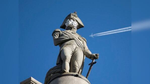 Activists protesting air pollution fit London statues with gas masks
