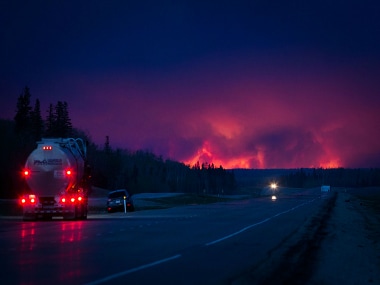 A truck drives on a highway as a wildfire burns south of Fort McMurray, Alberta, Canada. Getty Imags