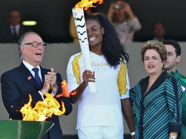 Brazilian volleyball player Fabiana Claudino holds the Olympic torch along with Brazilian President Dilma Rousseff. AFP