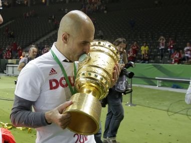 Bayern Munich head coach Pep Guardiola kisses the trophy after winning the German Cup. AP