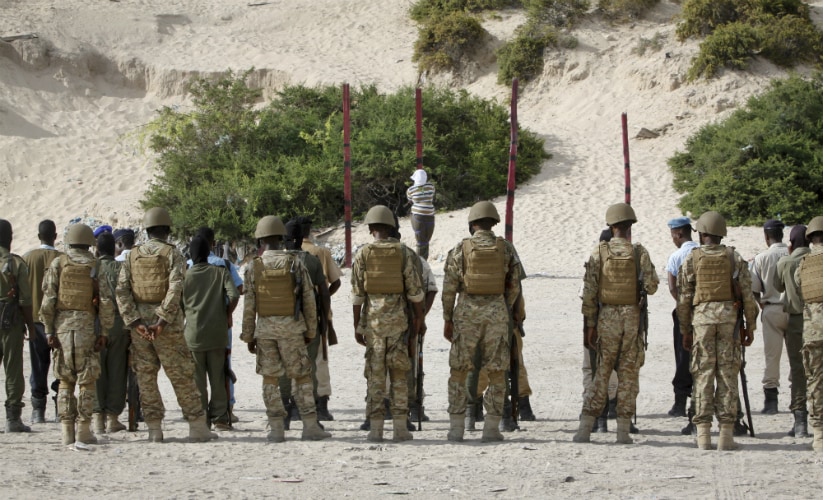 Hassan Hanafi Haji, center, a former journalist accused of belonging to al-Shabab and involvement in the killings of five Somali journalists, is tied to a wooden post as he is prepared to be executed by firing squad, at a police academy in Somalia on 11 April. AP