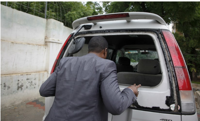 Abdiqadir Dulyar, director of Horn Cable, looks at the smashed window of a car that was carrying journalists working for his station, that unidentified gunmen opened fire on last week, in Mogadishu, Somalia. AP
