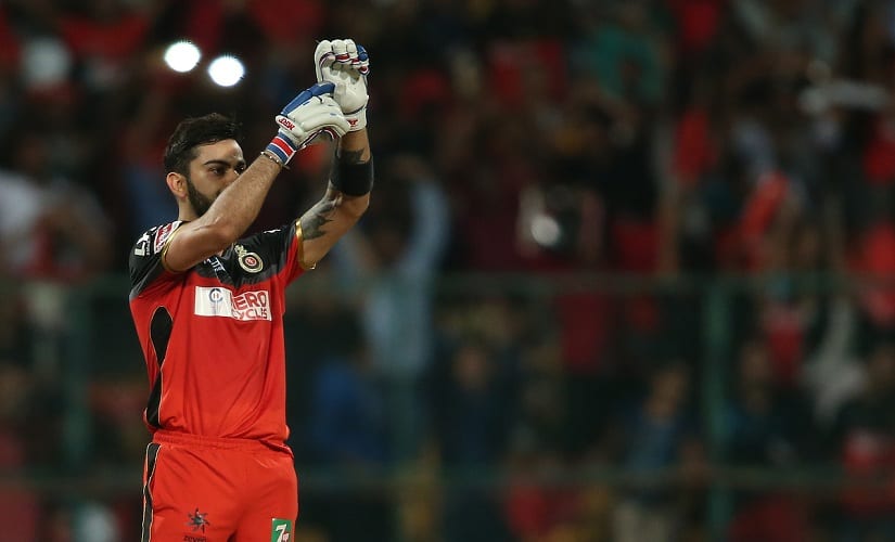 RCB captain Virat Kohli celebrates his century by pointing to his injured hand with stitches. BCCI