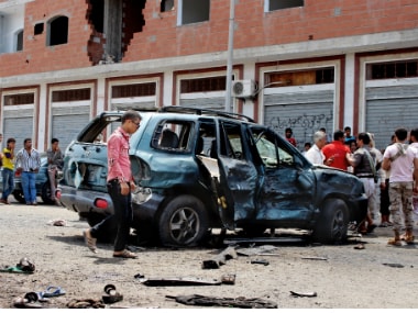 People gather at the scene after a pair of suicide bombings attack in the southern city of Aden in Yemen on Monday. AP