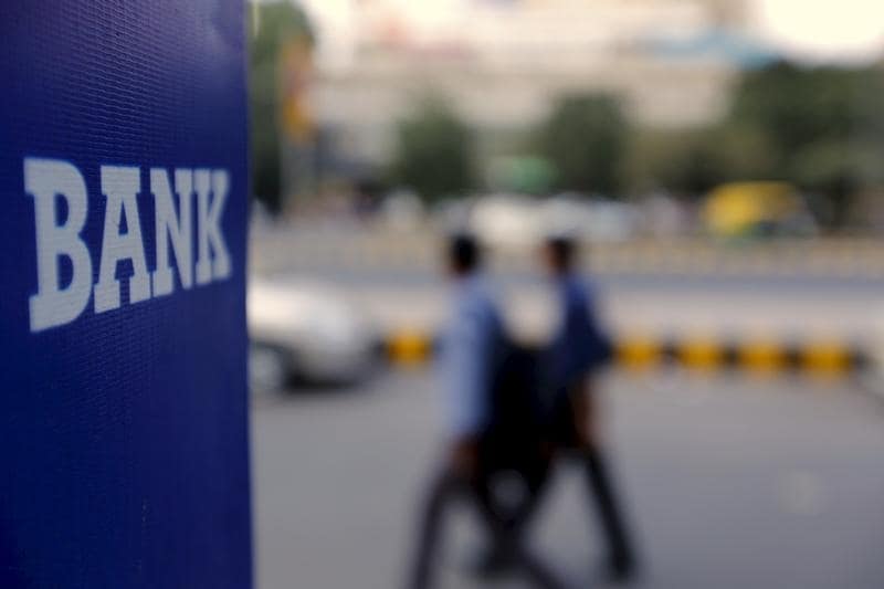 Commuters walk past a bank sign along a road in New Delhi in this November 25, 2015 file photo. REUTERS/Anindito Mukherjee/Files