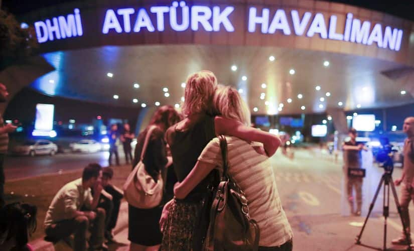 Passengers embrace each other at the entrance to Istanbul's Ataturk airport. AP