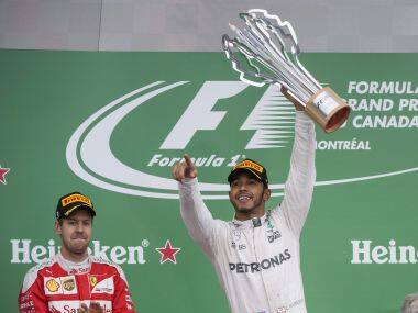 Lewis Hamilton celebrates his victory next to second-placed Sebastian Vettel. AP