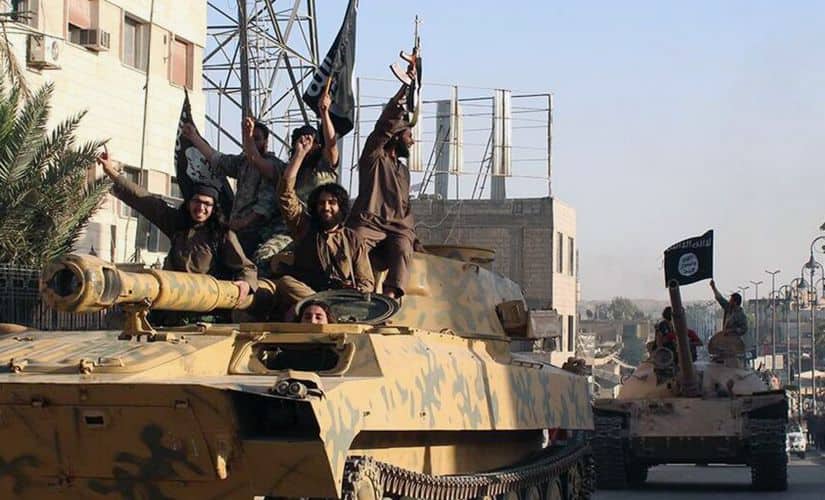 Fighters from the Islamic State group ride tanks during a parade in Raqqa, Syria. AP