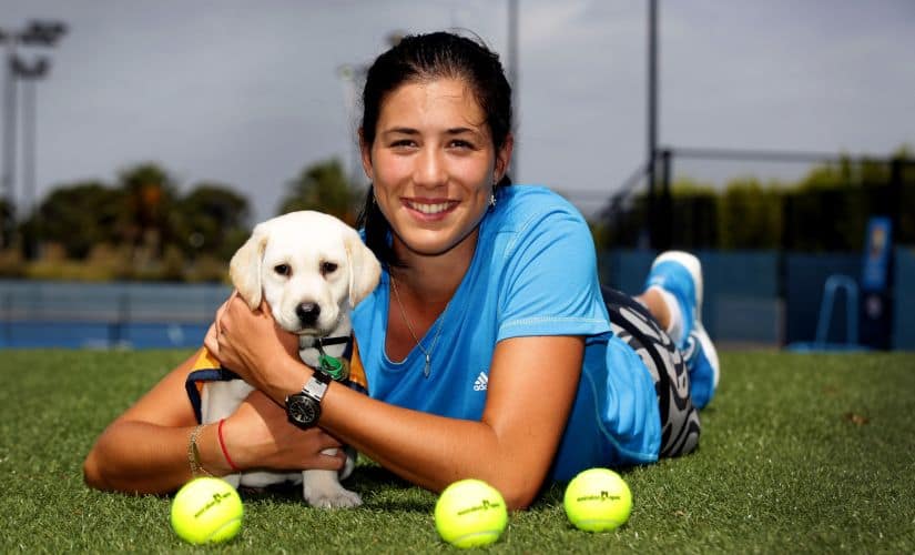 Garbine Muguruza poses with a guide dog puppy during the 2014 Australian Open. AFP