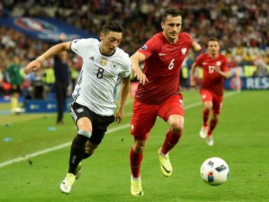 Germany's Mesut Ozil (L) vies for the ball against Poland's Tomasz Jodlowiec. AFP