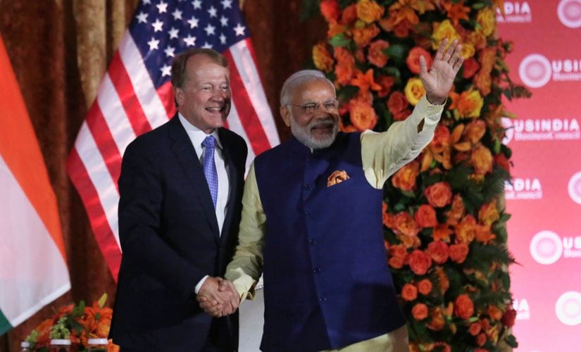 Prime Minister Narendra Modi waves and shakes hands with USIBC chairman John Chambers. Reuters