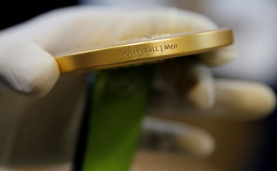 A worker shows an Olympic medal for men's volleyball. (REUTERS/Sergio Moraes)