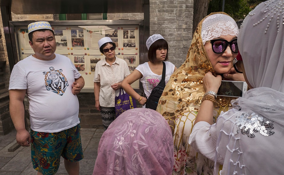 A Chinese Hui Muslim woman helps another with her headscarf before Eid prayers. Of an estimated 23 million Muslims in China, roughly half are Hui, who are ethnically Chinese and speak Mandarin. Getty images A Chinese Hui Muslim woman helps another with her headscarf before Eid prayers. Of an estimated 23 million Muslims in China, roughly half are Hui, who are ethnically Chinese and speak Mandarin. Getty images