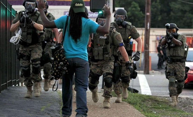 An unarmed demonstrator faces the police officers as they come towards him. AP