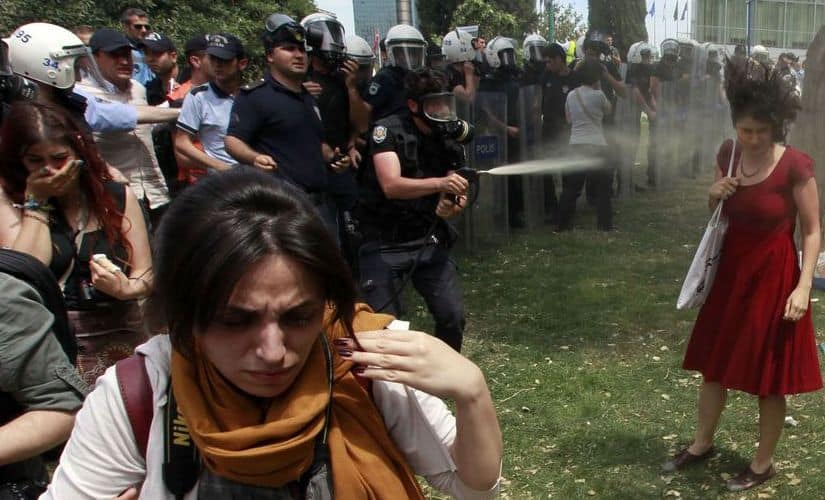 The girl in the red dress took the policeman’s tear gas shower on her face. Reuters