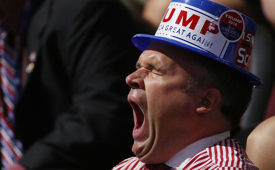 A delegate wearing a Trump hat yawns during the third day of the convention. At dozens of points throughout Cleveland, there are traders selling Trump paraphernalia, including the now-famous A delegate wearing a Trump hat yawns during the third day of the convention. At dozens of points throughout Cleveland, there are traders selling Trump paraphernalia, including the now-famous
