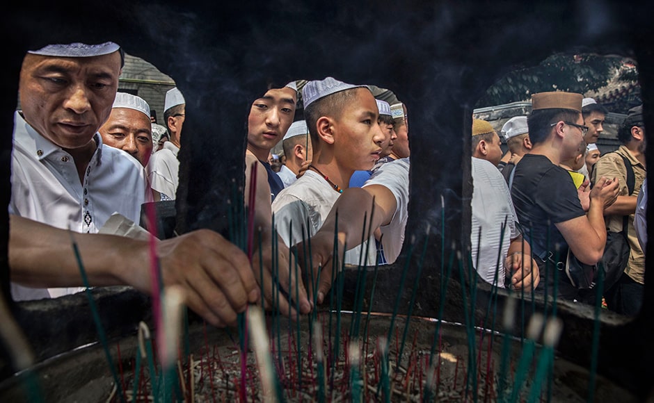 Chinese Hui Muslim men light incense at the 'Sheiks Tombs' after Eid prayers. Getty images Chinese Hui Muslim men light incense at the 'Sheiks Tombs' after Eid prayers. Getty images