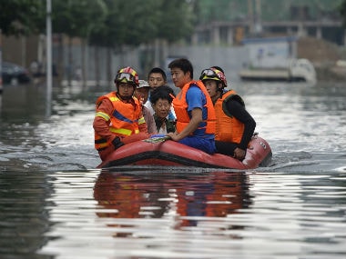 Rescuers use rafts to ferry people from flood hit areas. AP