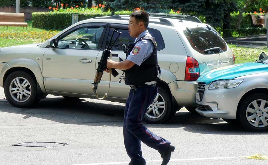 A policeman runs across the street in Almaty. While fleeing from the police station, one of the gunmen shot and killed a local resident before hijacking his car, the police said. Reuters A policeman runs across the street in Almaty. While fleeing from the police station, one of the gunmen shot and killed a local resident before hijacking his car, the police said. Reuters