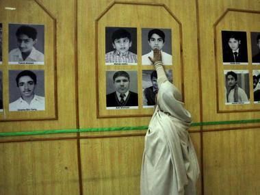 The mother of Uzair, an Army Public School victim, touches his picture in a gallery of the victims on the anniversary of the Taliban attack on the school in Peshawar. Reuters