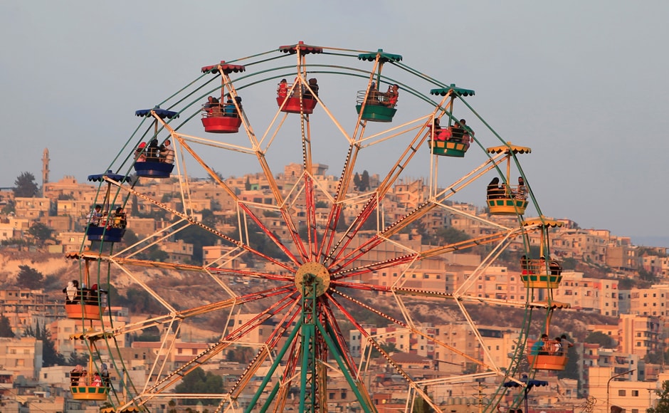 People ride a Ferris wheel in an amusement park as they celebrate the first day of the Muslim holiday of Eid al-Fitr, which marks the end of the holy month of Ramadan at the port-city of Sidon, southern Lebanon. Reuters People ride a Ferris wheel in an amusement park as they celebrate the first day of the Muslim holiday of Eid al-Fitr, which marks the end of the holy month of Ramadan at the port-city of Sidon, southern Lebanon. Reuters