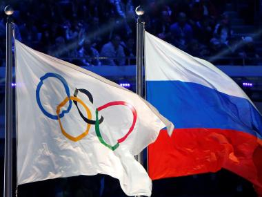 Russian flag (R) alongside the Olympic flag. Reuters