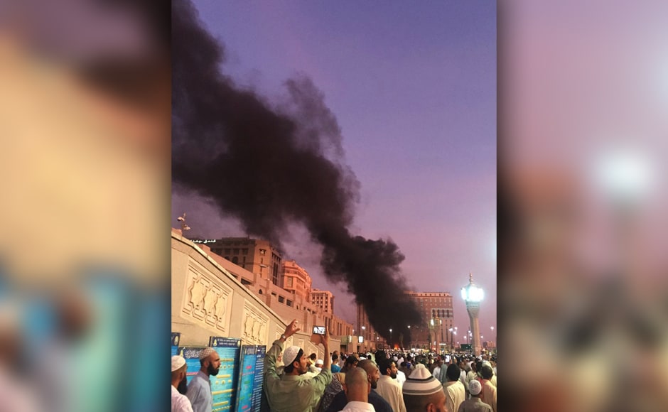 People stand near the explosion site as two suicide bombers struck in different cities in Saudi Arabia. Photo Courtesy: AP People stand near the explosion site as two suicide bombers struck in different cities in Saudi Arabia. Photo Courtesy: AP