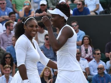 Venus Williams Serena Williams laugh together during their doubles match at Wimbledon.