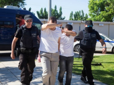 Two of the eight Turkish soldiers, who fled to Greece, are brought to prosecutor in the Greek city of Alexandroupolis on Sunday. Reuters