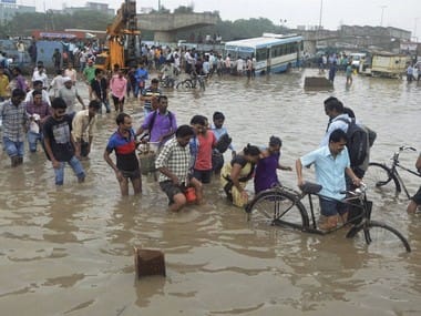 Gurgaon: People wade through a water logged street at Hero Honda Chowk on flooded Delhi-Gurgaon Expressway in Gurgaon on Friday. PTI 