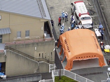 Ambulance crew and police officers are seen outside a facility for the handicapped where a number of people were killed and dozens injured in a knife attack on Tuesday. AP