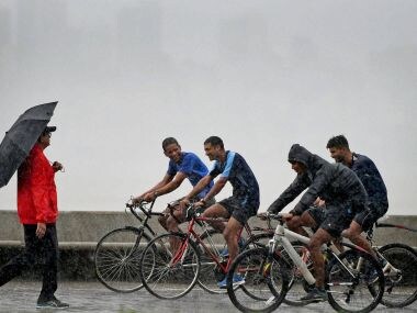 People enjoy the rains at Marine Drive in Mumbai on Friday. PTI