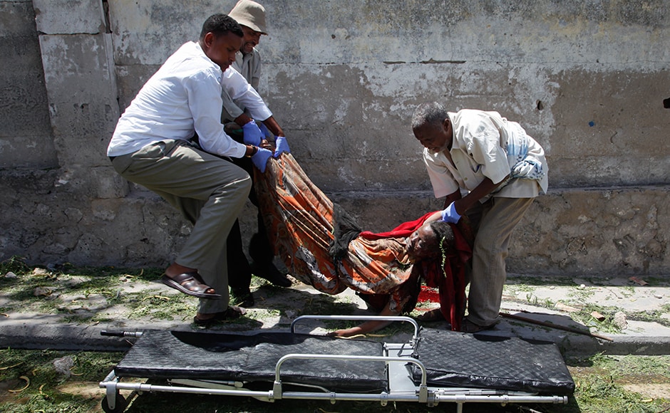 The blast damaged nearby hotels often frequented by government officials and business executives. A woman who was among the 12 dead is being carried away after the blast by some Somali men. AP The blast damaged nearby hotels often frequented by government officials and business executives. A woman who was among the 12 dead is being carried away after the blast by some Somali men. AP