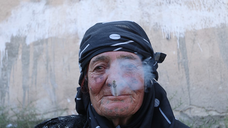 A woman smokes as she rests after she was evacuated by the SDF fighters . <em>AFP</em> footage showed the city's streets strewn with rubble and a wall still painted with the jihadists' black and white flag. Reuters A woman smokes as she rests after she was evacuated by the SDF fighters . <em>AFP</em> footage showed the city's streets strewn with rubble and a wall still painted with the jihadists' black and white flag. Reuters