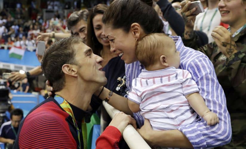 Michael Phelps celebrates his win with fiance Nicole Johnson and baby Boomer. AP