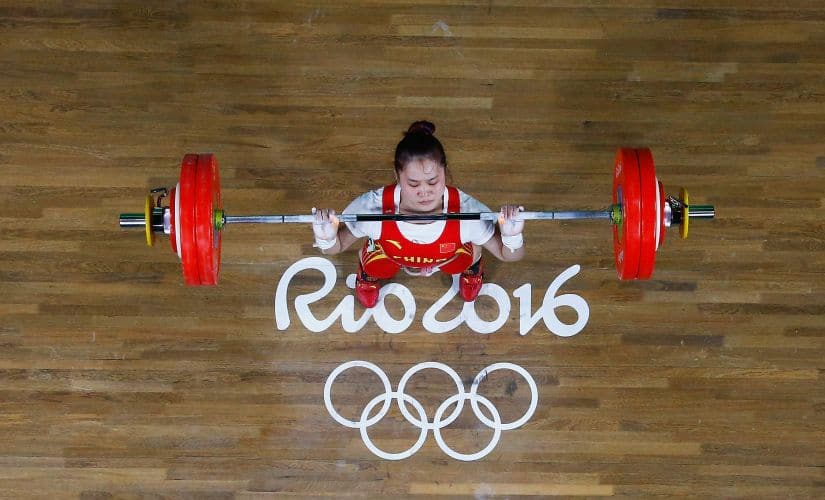 Wei Deng ifts to secure winning the gold medal during the Women's 63kg Group A Weightlifting. Getty
