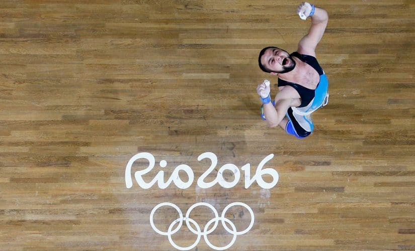 Nijat Rahimov celebrates after lifting during the Men's 77kg Group A weightlifting contest. Getty