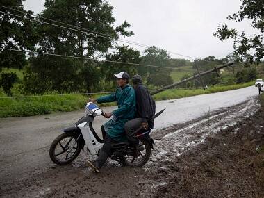 Power lines collapsed by Hurricane Earl hinder traffic flow on the road from Flores, in the northern Guatemalan border state with Belize, Thursday, Aug. 4, 2016. Earl deteriorated to a weak tropical storm Thursday as it passed over northern Guatemala en route to southern Mexico. (AP Photo/Luis Soto)