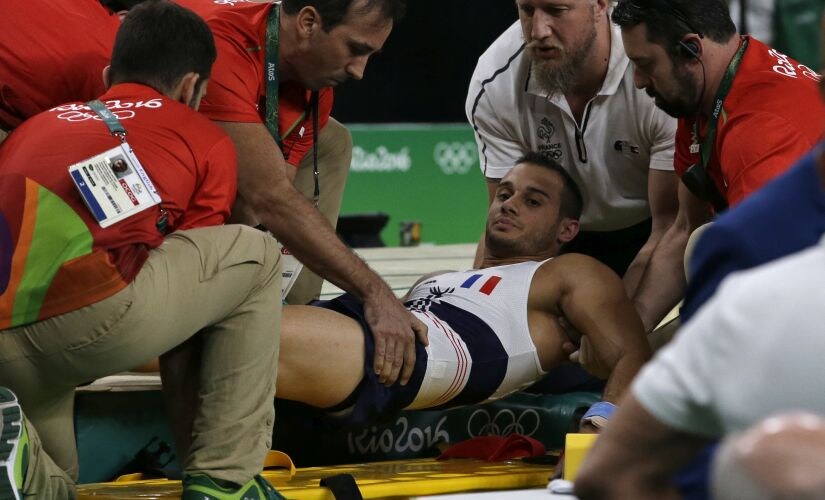 Samir Ait Said is assisted after injuring his leg in the vault during the artistic gymnastics men's qualification. AP