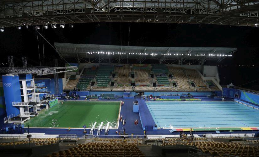 The water of the diving pool appears a murky green, in stark contrast to the pool's previous day's color. AP