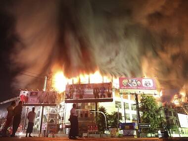 People stand near a fire at Minglar market in Yangon on 9 January, 2016. Reuters 