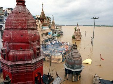Cremations being performed on the roof a building as the famous Manikarnika Ghat is seen flooded in Varanasi on Monday. PTI