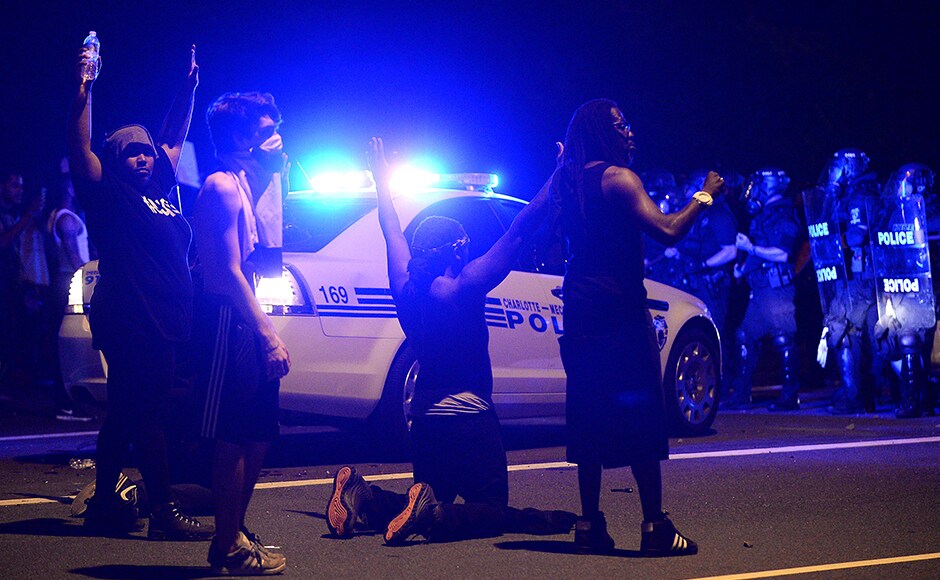 Protesters demonstrate in front of police. Authorities used tear gas to disperse protesters in an overnight demonstration that broke out Tuesday after Keith Lamont Scott was fatally shot by an officer at an apartment complex. AP Protesters demonstrate in front of police. Authorities used tear gas to disperse protesters in an overnight demonstration that broke out Tuesday after Keith Lamont Scott was fatally shot by an officer at an apartment complex. AP